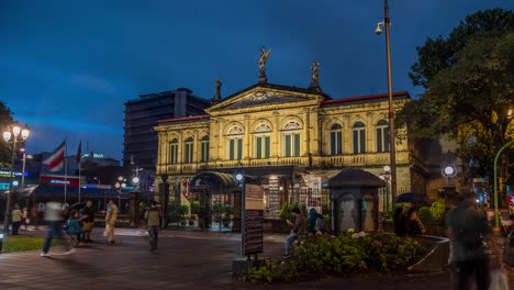 Muchos-Peatones-Caminan-Frente-Al-Teatro-Nacional-En-La-Ciudad-Capital-De-San-Jose-Durante-El-Anochecer