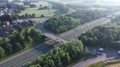 Aerial-rising-tilt-down-view-lush-countryside-farmland-woodland-rural-M62-motorway,-Rainhill,-England