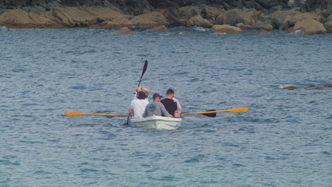 Grupo-De-Hombres-Adultos-Se-Unen-Tranquilamente-A-Través-De-Botes-De-Remo-En-Las-Serenas-Aguas-De-La-Playa-De-Porthallow,-Cornualles,-Inglaterra,-Reino-Unido