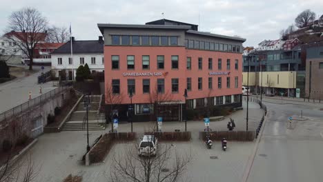 Sparebanken-Sor-bank-building-in-Vestervei-Arendal-Norway---Aerial-gently-moving-towards-building-with-logo