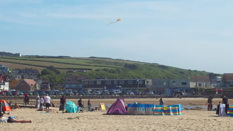 Kite-Flying-On-Perranporth-Beach,-Cornwall,-UK---wide,-slow-motion