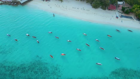 Nungwi-Beach,-Zanzibar---Tanzania---June-18,-2022---Boats-on-the-Indian-ocean-on-a-sunny-cloudy-day-during-sunrise