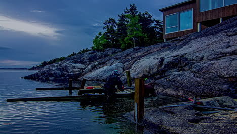 Timelapse-shot-of-workers-building-wooden-jetty-along-rocks-beside-blue-lake-throughout-a-summer-day-in-timelapse