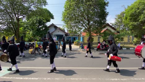 Rows-of-royal-soldiers-or-Bregodo-parade-in-historic-costumes-during-the-celebration-of-the-founding-of-the-city-of-Bantul,-while-carrying-musical-instruments