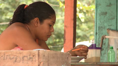 Indigenous-woman-in-the-countryside-near-Manaus,-Brazil-eating-in-the-community-kitchen