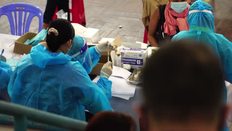 COVID-nurses-at-vaccine-center-in-wearing-blue-PPE-giving-vaccine-to-patients