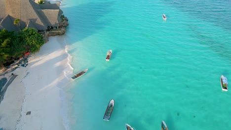 Nungwi-Beach,-Zanzibar---Tanzania---June-18,-2022---Boats-on-the-Indian-ocean-on-a-sunny-cloudy-day-during-sunrise