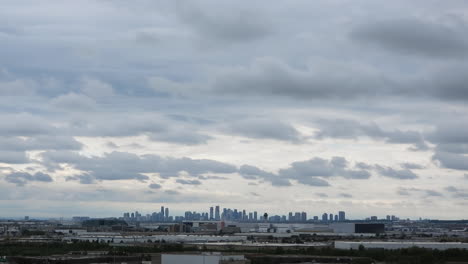 Time-Lapse-of-Toronto-Skyline-in-the-distance,-grey-clouds-Moving-fast-in-the-sky,-Canada