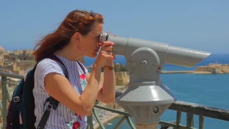 Woman-Looking-At-Seascape-Through-Binoculars-On-A-Sunny-Windy-Day