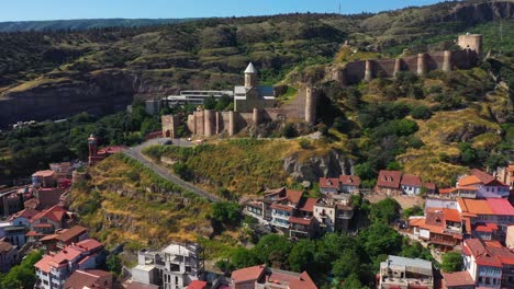 Aerial:-Tbilisi-city-with-Narikala-Fortress-on-hillside,-Georgia