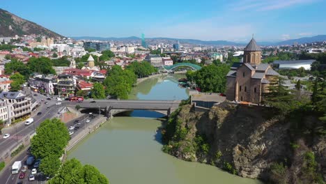 Aerial-shot-of-Tbilisi-city,-river-Kura-and-Metekhi-Church-in-Georgia