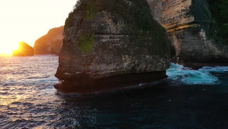 Aerial-footage-of-big-and-small-rocks-washed-by-blue-water-of-ocean,-Nusa-Penida,-Bali,-Indonesia