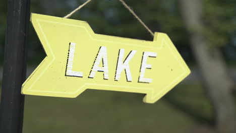 Tilt-up-to-reveal-small-yellow-sign-pointing-to-the-Lake