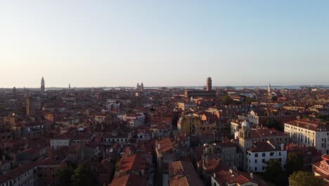 Beautiful-rising-aerial-view-over-the-buildings-in-Venice,-Italy-under-the-late-afternoon-sun