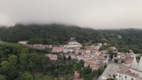 Housing-townscape,-residence-town-palace-with-Sintra-mountain-covered-with-thick-fog,-aerial-pull-out-shot