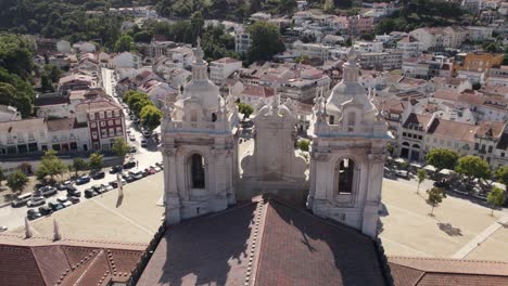 Aerial-pan-shot-of-cistercian-monastery-of-Alcobaca-overlooking-at-front-foyer-and-housing-townscape