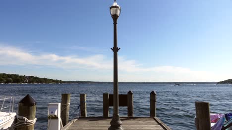 Light-pole-at-the-end-of-a-pier-overlooking-the-water-on-a-sunny-day,-no-person