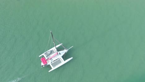 Großes-Weißes-Boot-Langsame-Bewegung-Auf-Dunkelgrünem-Wasser,-Um-Die-Sonne-Bei-Sonnenuntergang-Zu-Treffen,-Draufsicht-Auf-Das-Boot-4k-Video