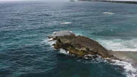 Rocky-Coastline-And-Turquoise-Ocean-Water-At-La-Poza-del-Obispo-Beach-In-Arecibo,-Puerto-Rico---aerial-drone-shot