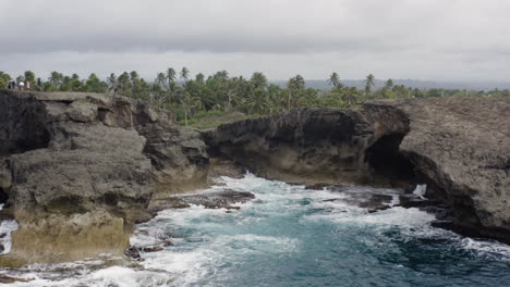 Schaumige-Meereswellen,-Die-über-Felsige-Klippen-An-Der-Cueva-Del-Indio-In-Las-Piedras,-Puerto-Rico,-Stürzen---Luftdrohnenaufnahme