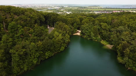 Aerial-pan-above-Emerald-Lake,-looking-at-Szczecin-city-and-Dabie-Lake
