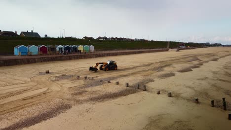 Aerial-Drone-Footage-of-a-Digger-Working-Along-Gorleston-On-Sea-Beach,-Norfolk