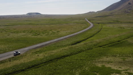 Conducción-De-Vehículos-En-El-Largo-Camino-En-Medio-Del-Campo-Verde-En-Snaefellsnes,-Islandia