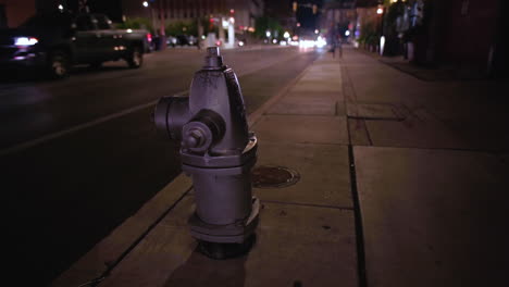 Silver-fire-hydrant-by-the-road-and-traffic-in-Tucson,-Arizona--Close-up