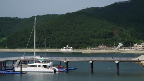 Catamaran-Boat-On-Jetty-With-Tourist-In-Hanwha-Resort-Geoje-Belvedere,-South-Korea