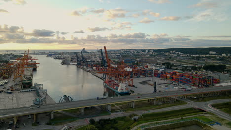 Aerial-shot-of-industrial-cargo-shipyard-with-colorful-cranes-beside-highway-in-Gdynia,Poland