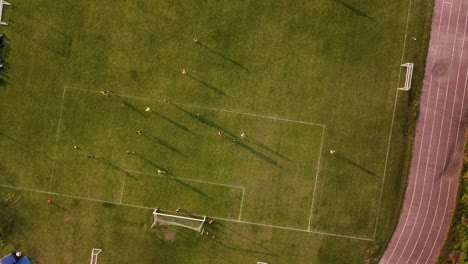 Aerial-top-down-view-of-women's-football-team-play-in-a-gardeng