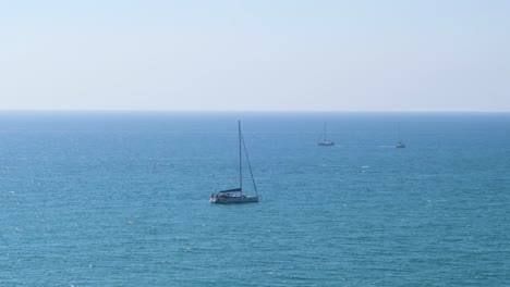 Weißes-Boot-Vor-Der-Küste-Verankert-Mit-Klarem-Himmel-Und-Sonnigem-Tag