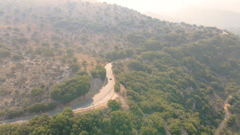 Aerial-View-Of-Lone-Car-Driving-At-Road-Mountains-Of-Crete-Island,-Greece