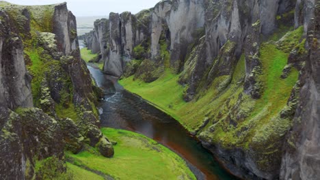 Einzigartige-Zerklüftete-Landschaft-Der-Fjaðrárgljúfur-Schlucht,-Bedeckt-Von-Wunderschönem-Grünem-Moos,-In-Südisland-Gelegen---Luftaufnahme