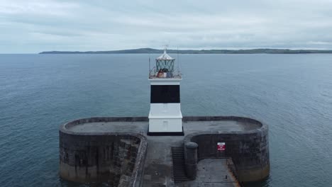 Holyhead-breakwater-lighthouse-longest-concrete-coastal-sea-protection-landmark-aerial-view-forward-establishing