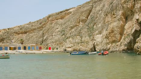 Barcos-Flotando-En-Aguas-Tranquilas-Del-Mar-Interior-De-Dwejra-Con-Cueva-Marina-Natural-En-Malta