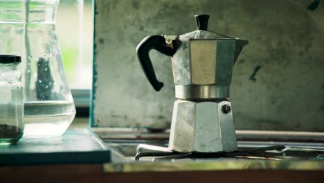 Classic-old-school-moka-pot-brewing-coffee-on-gas-stove,-close-up