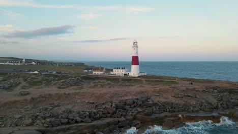 Footage-of-the-drone-standing-still-in-front-of-Portland-Bill's-lighthouse,-in-Dorset-England,-during-a-beautiful-sunset