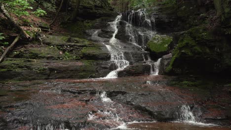 Ein-Wasserfall-Im-Wald-Im-Sommer-Mit-Grünem-Moos,-Das-Auf-Den-Felsen-Wächst