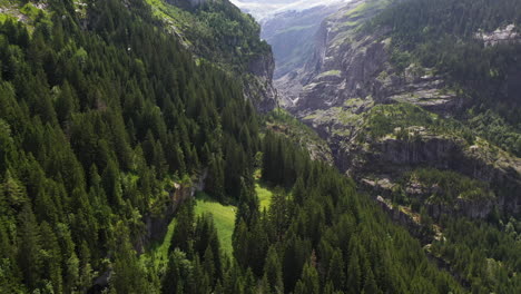 Revealing-drone-shot-of-mountains-near-Grindelwald,-in-Switzerland’s-Bernese-Alps,-with-a-waterfall-in-the-distance