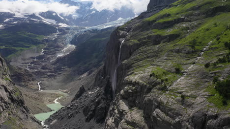Cinematic-drone-shot-waterfall-near-Grindelwald,-in-Switzerland’s-Bernese-Alps,-flying-in-valley
