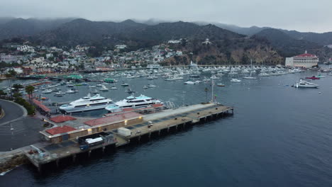 Wide-Aerial-Panning-Shot-of-Avalon-Bay-Passenger-Ships,-Harbor,-and-Casino,-Santa-Catalina
