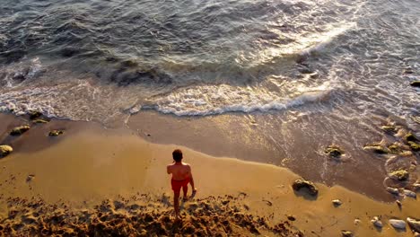 Mann-Geht-Am-Strand-Spazieren,-Um-Während-Des-Sonnenuntergangs-Im-Libanon-Auf-Dem-Meer-Zu-Schwimmen