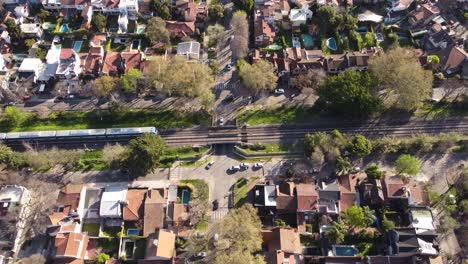 Aerial-top-down-showing-passing-train-and-car-traffic-in-Vicente-Lopez-Residential-Area-in-Buenos-Aires