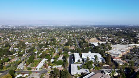 Sunnyvale-City-Aerial-view-with-trees,-main-road,-houses,-and-mountains-in-background-in-the-afternoon-drone-move-forward