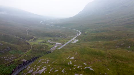 Cars-Driving-A82-through-Scenic-Glencoe-Mountain-Pass-Road,-Scottish-Highlands,-Scotland---Aerial-Drone-4K-HD-Footage