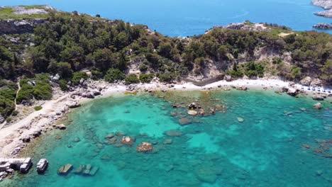 Toma-Cinematográfica-De-Drones-Que-Muestra-Una-Playa-Impresionante-En-Grecia-Alejándose-De-La-Orilla-Mientras-Pasan-Las-Gaviotas