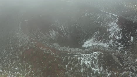Flying-Above-Clouds-and-Inactive-Volcano-Crater-on-Cold-Winter-Day,-Drone-Aerial-View-of-Bandera-Volcano,-New-Mexico-USA