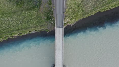 Bridge-crossing-main-stem-river-mixing-with-tributary-in-Iceland,-Confluence
