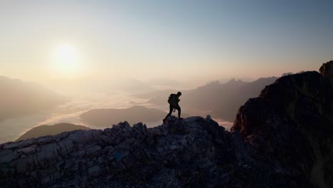 A-mountaineer-is-hiking-on-a-ridge-and-looking-towards-the-sunrise